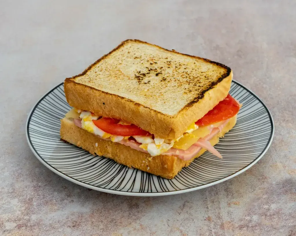 French Sandwich Jamón extra york, queso emmental, tortilla francesa con toque de queso, tomate, mayonesa y sus patatas fritas naturales