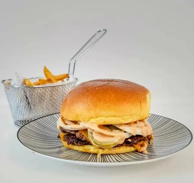 Cheese Burger Pan brioche, carne 100% vacuno de 200g cocinadas al estilo smash burger, doble queso cheddar fundido, pepinillo, cebolla salsa burger o ketchup y mostaza con sus patatas naturales