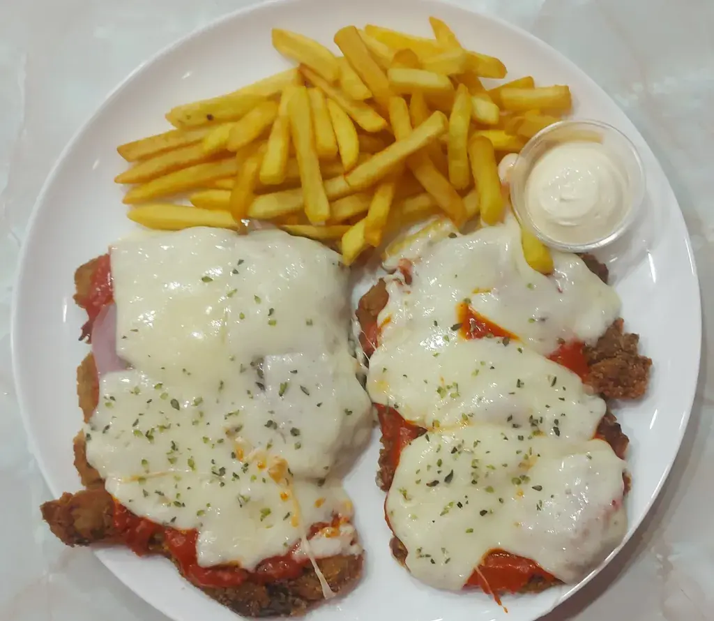 Milanesa de berenjena napolitana Berenjena empanada frita con salsa de tomate jamon y queso