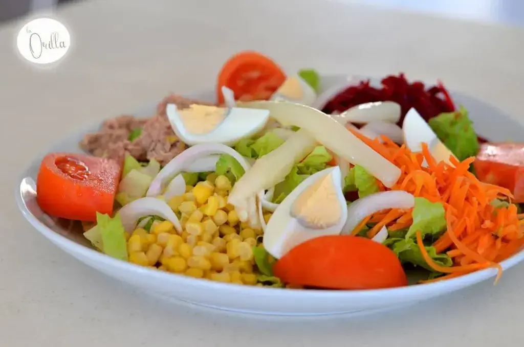 Ensalada de la casa Lechuga, tomate, cebolla, maiz, huevo duro, espárragos, atún, zanahoria, remolacha