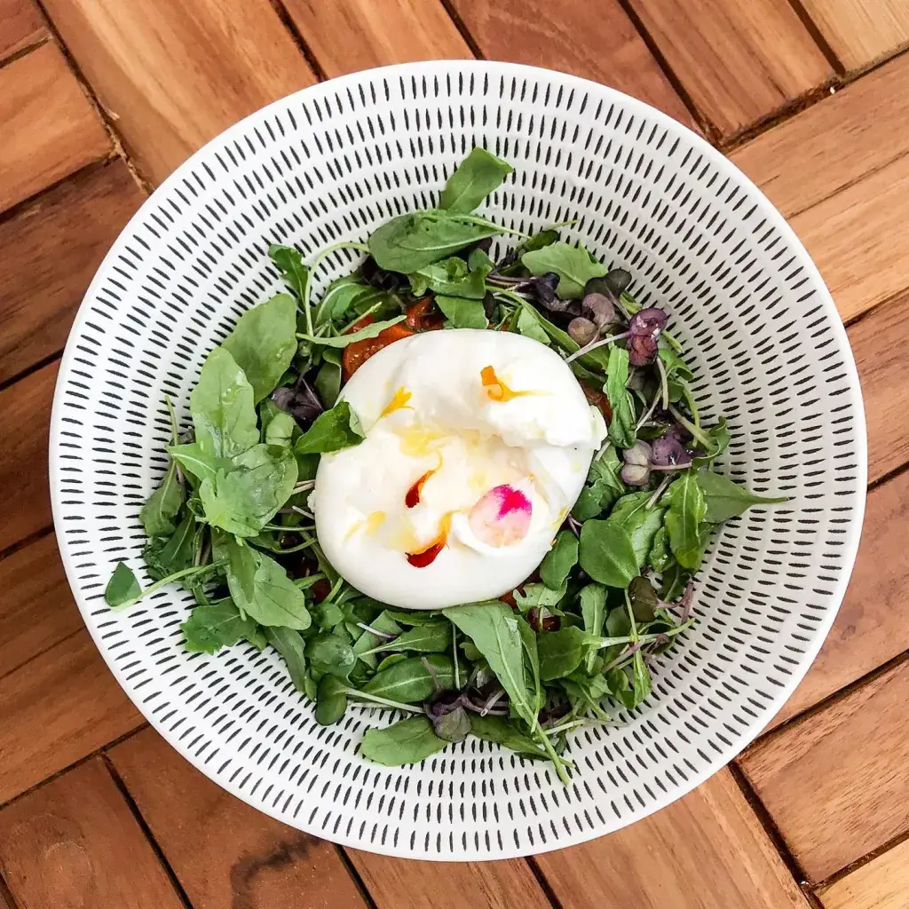 Burrata fresca, tomates confitados, rúcula y aceitunas