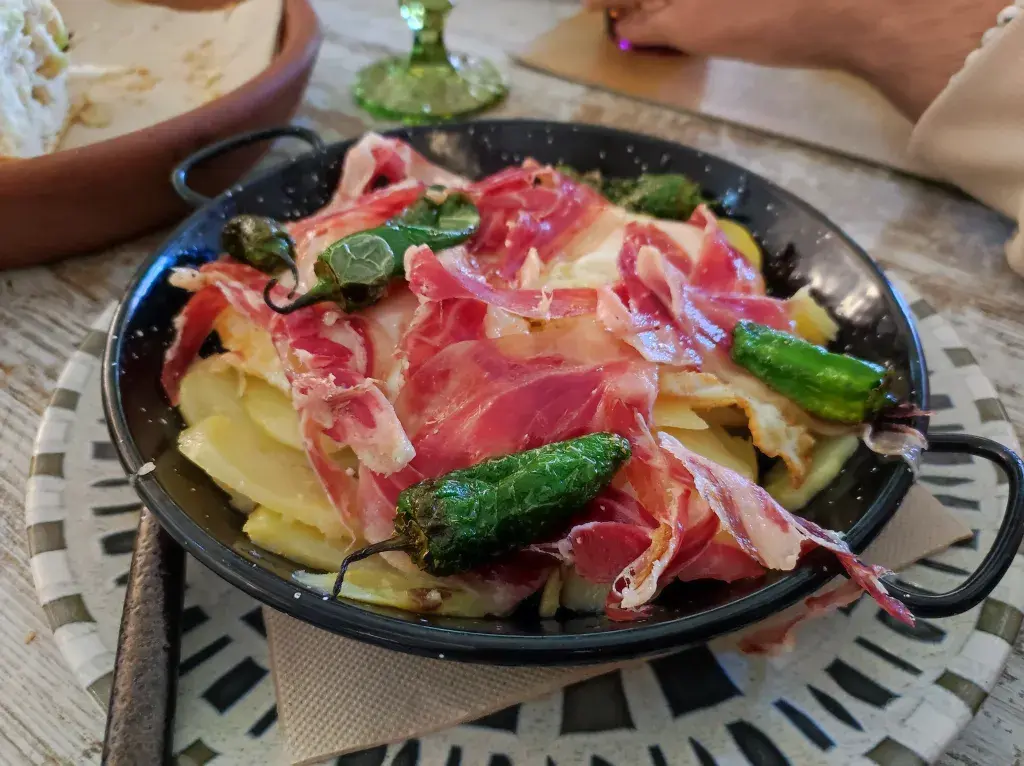 Sartencita de huevos camperos, jamón Ibérico, patata confitada y pimientos de padrón