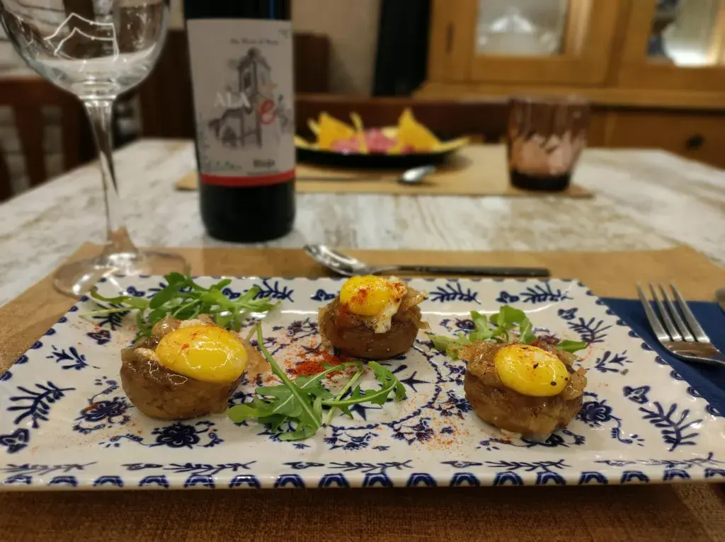 Champiñón relleno de panceta curada, cebolla caramelizada y huevo de codorniz