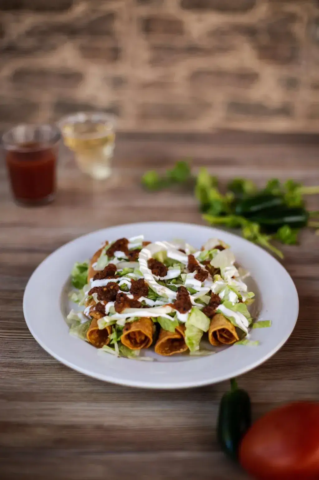 Tacos dorados de pollo Cuatro tacos en tortilla de 15 centímetros rellenos de pollo y fritos, adornados con lechuga picada, salsa de jalapeño (no picante), y crema ácida.