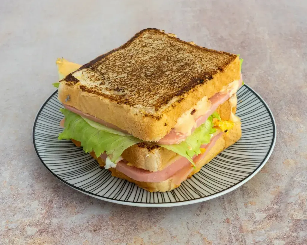 Sandwich classic Jamón extra york, queso emmental, huevo a la plancha, mayosiracha y lechuga formado en dos pisos, con sus patatas fritas naturales